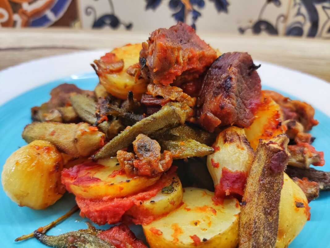 Ένα μεγάλο πιάτο γεμάτο με ζουμερό Μοσχάρι με Μπάμιες στο Φούρνο και φρέσκες πατάτες, έτοιμο για σερβίρισμα.