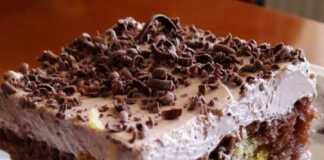 Κομμάτι από δίχρωμο κέικ με ορατές τις στρώσεις παντεσπανιού και κρέμας.