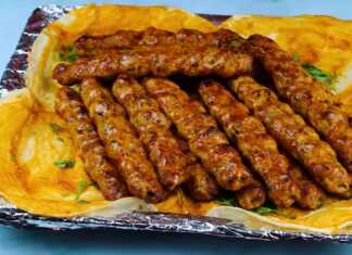 Σειρά από καλοψημένα κεμπάπ κοτόπουλου πάνω σε ξυλάκια τοποθετημένα σε σχάρα φούρνου με γυαλιστερή σάλτσα