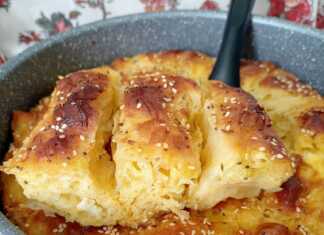 Ροδισμένα ρολάκια τυρόπιτας τοποθετημένα σφιχτά σε ταψί πασπαλισμένα με σουσάμι και παπαρουνόσπορο