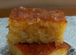 Κομμάτια πορτοκαλόπιτας σερβιρισμένα σε πιάτο, με υγρή, αφράτη υφή, περιχυμένα με χρυσαφένιο σιρόπι πορτοκαλιού