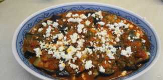 Ένα πιάτο γεμάτο με λαχταριστά Ρολάκια Μελιτζάνας με τυρί, με ροδισμένη φέτα στην επιφάνεια, έτοιμα για σερβίρισμα