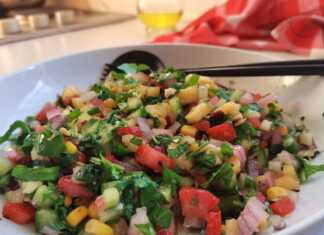 Έγχρωμη σαλάτα του καλοκαιριού σε ένα μπολ, με ρόκα, καλαμπόκι, ανανά, φράουλες, αγγούρι και θρυμματισμένα αμύγδαλα, γαρνιρισμένη με μαύρο σουσάμι.