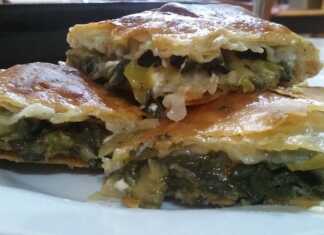 Τραγανή παραδοσιακή σπανακοτυρόπιτα με χρυσό χωριάτικο φύλλο, κομμένη σε τετράγωνα κομμάτια.