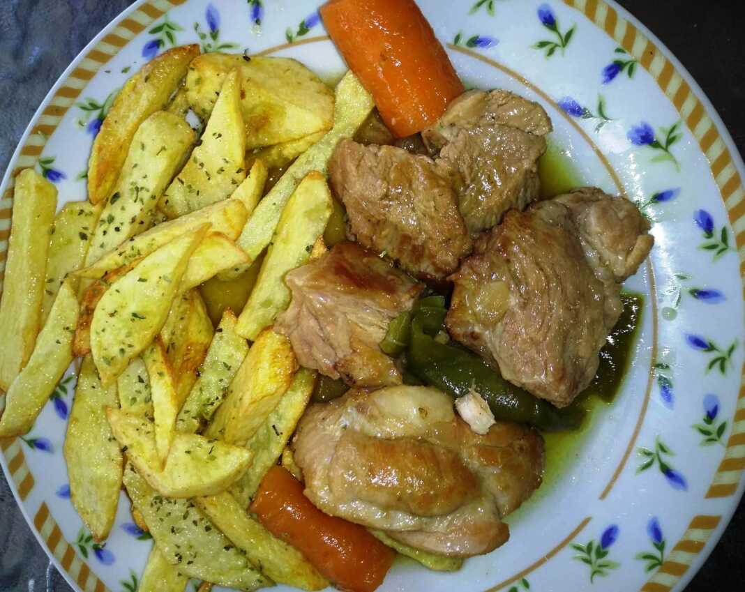 Λεμονάτο Χοιρινό Κατσαρόλας: Το κρέας σερβιρισμένο με πατάτες τηγανιτές.