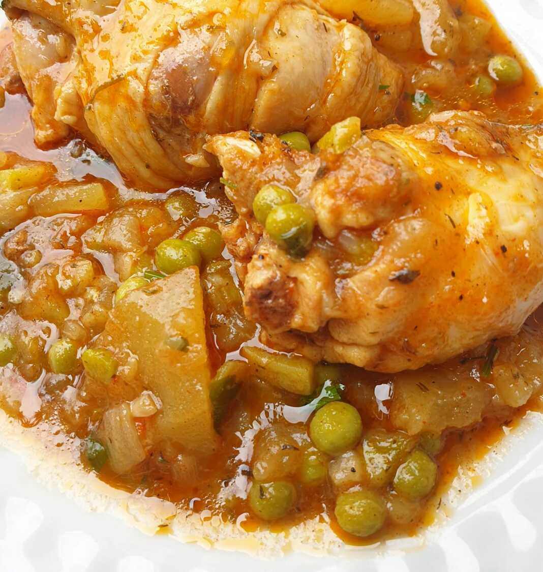 Πιάτο με μία μερίδα Κοτόπουλο με Αρακά, με κομμάτια κοτόπουλου, πατάτες και σάλτσα.