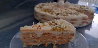 Τούρτα ψυγείου με στρώσεις μπισκότου και λευκής κρέμας, καλυμμένη ολόκληρη με τριμμένη καρύδα, διακοσμημένη με τρουφάκια Raffaello και φυστίκι αιγίνης.