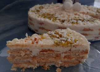 Τούρτα ψυγείου με στρώσεις μπισκότου και λευκής κρέμας, καλυμμένη ολόκληρη με τριμμένη καρύδα, διακοσμημένη με τρουφάκια Raffaello και φυστίκι αιγίνης.