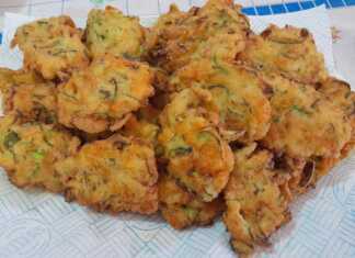 Χρυσαφένιες, τραγανές τηγανίτες με κολοκυθοανθούς σε πιάτο, γαρνιρισμένες με φρέσκο βασιλικό, σε ρουστίκ φόντο.