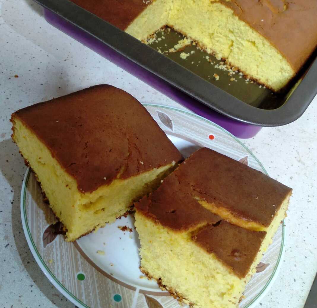 Keik Αφράτο κέικ πορτοκαλιού στο ταψί, κομμένο σε τετράγωνα κομμάτια.