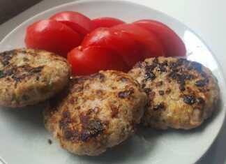 Καλοψημένα και ροδισμένα μπιφτέκια κοτόπουλο σε πιατέλα γαρνιρισμένα με φρέσκο μαϊντανό και φέτες λεμονιού