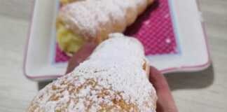 Ένα πιάτο με χρυσαφένια, κωνικά κορνεδάκια από σφολιάτα γεμισμένα με λευκή κρέμα πατισερί.