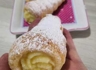 Ένα πιάτο με χρυσαφένια, κωνικά κορνεδάκια από σφολιάτα γεμισμένα με λευκή κρέμα πατισερί.