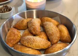 Χρυσαφένια Τυροπιτάκια Κουρού με σουσάμι σε ένα ταψί, έτοιμα να σερβιριστούν