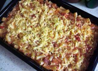 Ζυμαρικά ανακατεμένα με σάλτσα κιμά και λουκάνικου, καλυμμένα με τριμμένο κίτρινο τυρί, έτοιμα να βγουν από τον φούρνο.