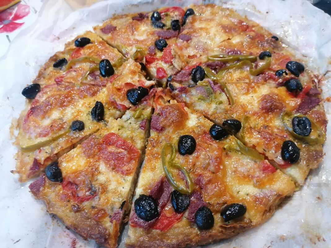 Μια ολόκληρη πίτσα με βάση κολοκυθιού, με τα υλικά της έτοιμα για ψήσιμο