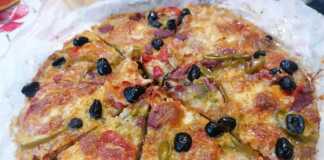 Μια ολόκληρη πίτσα με βάση κολοκυθιού, με τα υλικά της έτοιμα για ψήσιμο