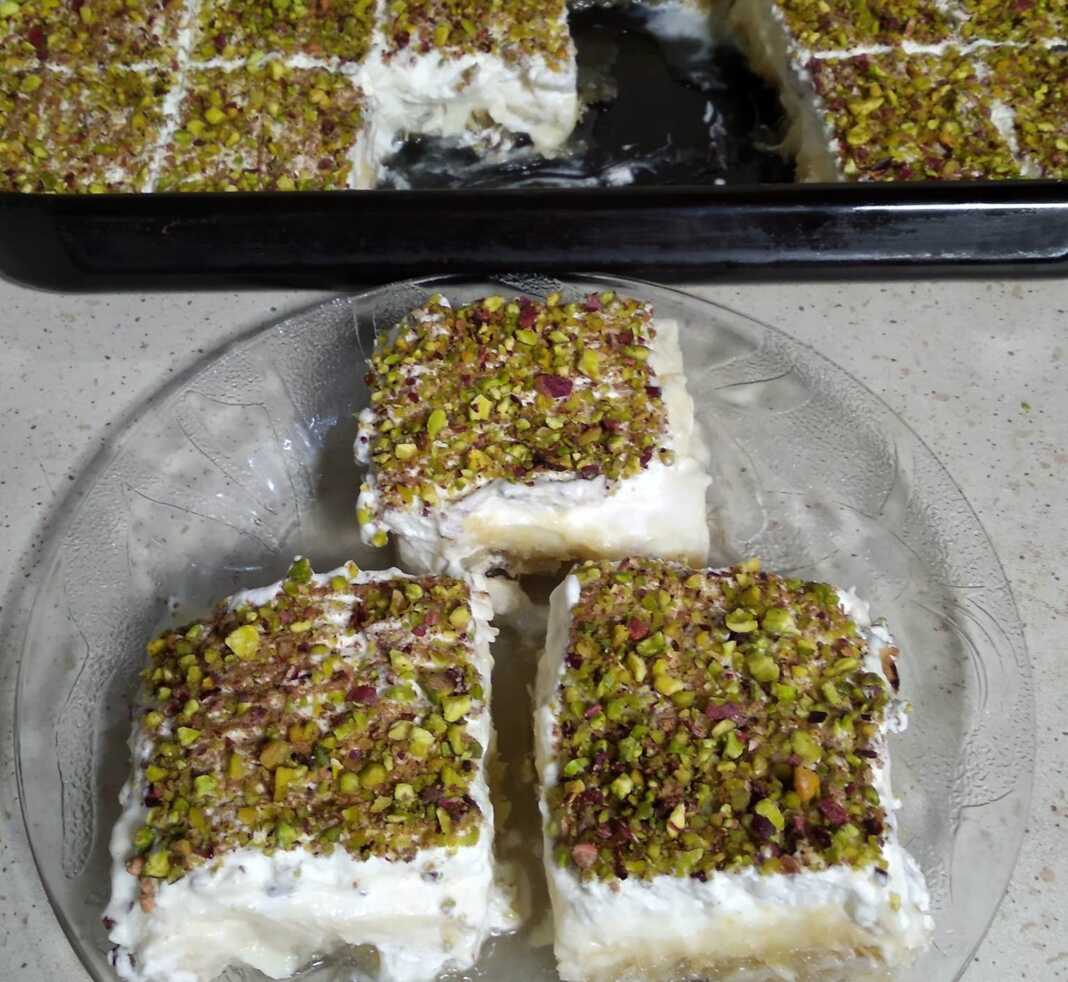 Εκμέκ κανταΐφι με σαντιγί και φυστίκι Αιγίνης, σερβιρισμένο σε κομμάτι.