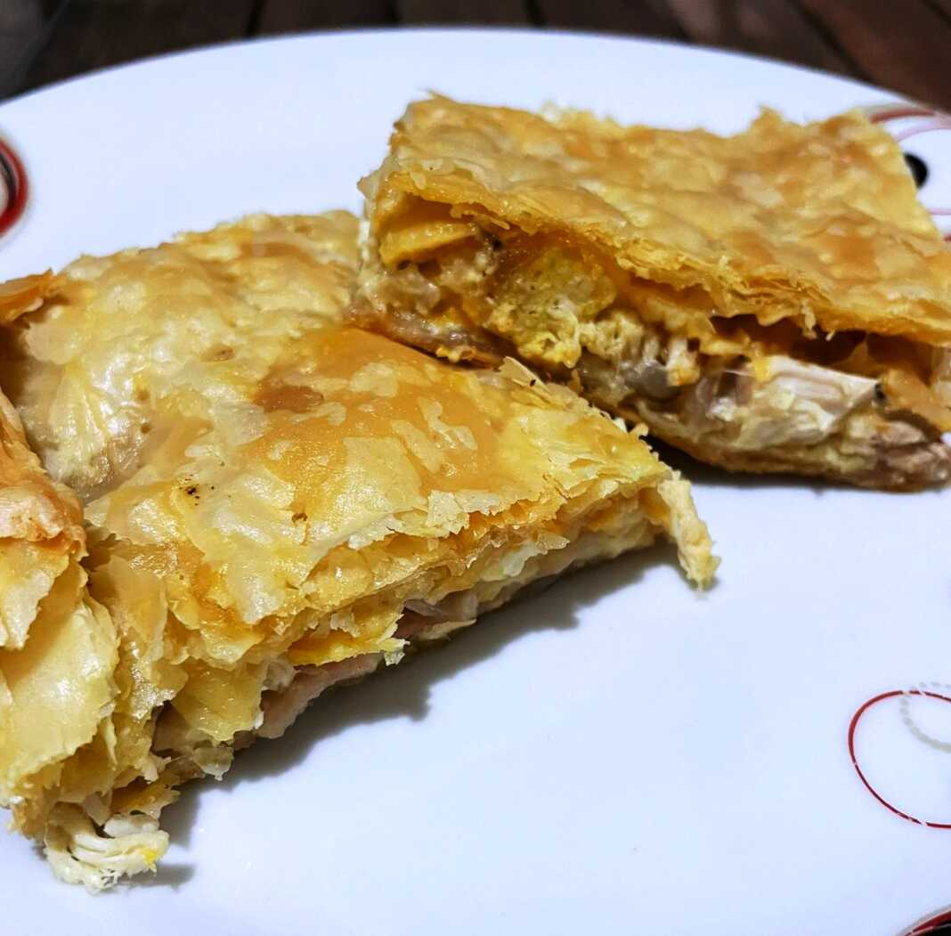 Φανταστική Κοτόπιτα με φύλλο σφολιάτας, χρυσαφένια, κομμένη σε τετράγωνα κομμάτια.