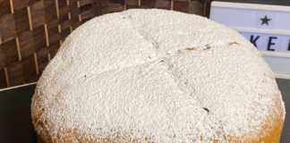 Ολόκληρη Μπουγάτσα της Παναγίας, χρυσαφένια και αφράτη, πασπαλισμένη με ζάχαρη άχνη, σε ξύλινη επιφάνεια