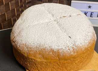 Ένας καλοψημένος, ροδοκόκκινος άρτος με χαραγμένο τον Σταυρό στην επιφάνεια, πασπαλισμένος με άφθονη ζάχαρη άχνη