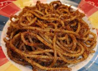 Σκορδομακαρονάδα με αντσούγιες, πασπαλισμένη με τραγανή φρυγανιά, σερβιρισμένη σε πιάτο.