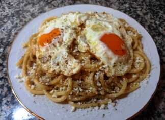 Πιάτο με Τσουχτή Μακαρονάδα, με τριμμένη μυζήθρα και ένα μελάτο αυγό μάτι στην κορυφή.