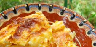 Μια μεγάλη φέτα από αφράτη τυρόπιτα σουφλέ σε ένα πιάτο