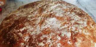 Φρεσκοψημένο χωριάτικο ψωμί με χρυσαφένια κρούστα, σε ξύλινη επιφάνεια