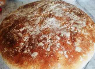 Φρεσκοψημένο χωριάτικο ψωμί με χρυσαφένια κρούστα, σε ξύλινη επιφάνεια