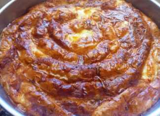 Μια ροδοκοκκινισμένη στριφτή κιμαδόπιτα σε στρογγυλό ταψί με το φύλλο να φαίνεται εξαιρετικά τραγανό και τη γέμιση πλούσια και μυρωδάτη