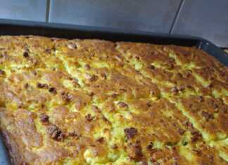 Ένα ταψι χρυσαφένιας κουρκουτόπιτας (μπατζίνας) με ορατά κομμάτια τριμμένου κολοκυθιού και φέτας.