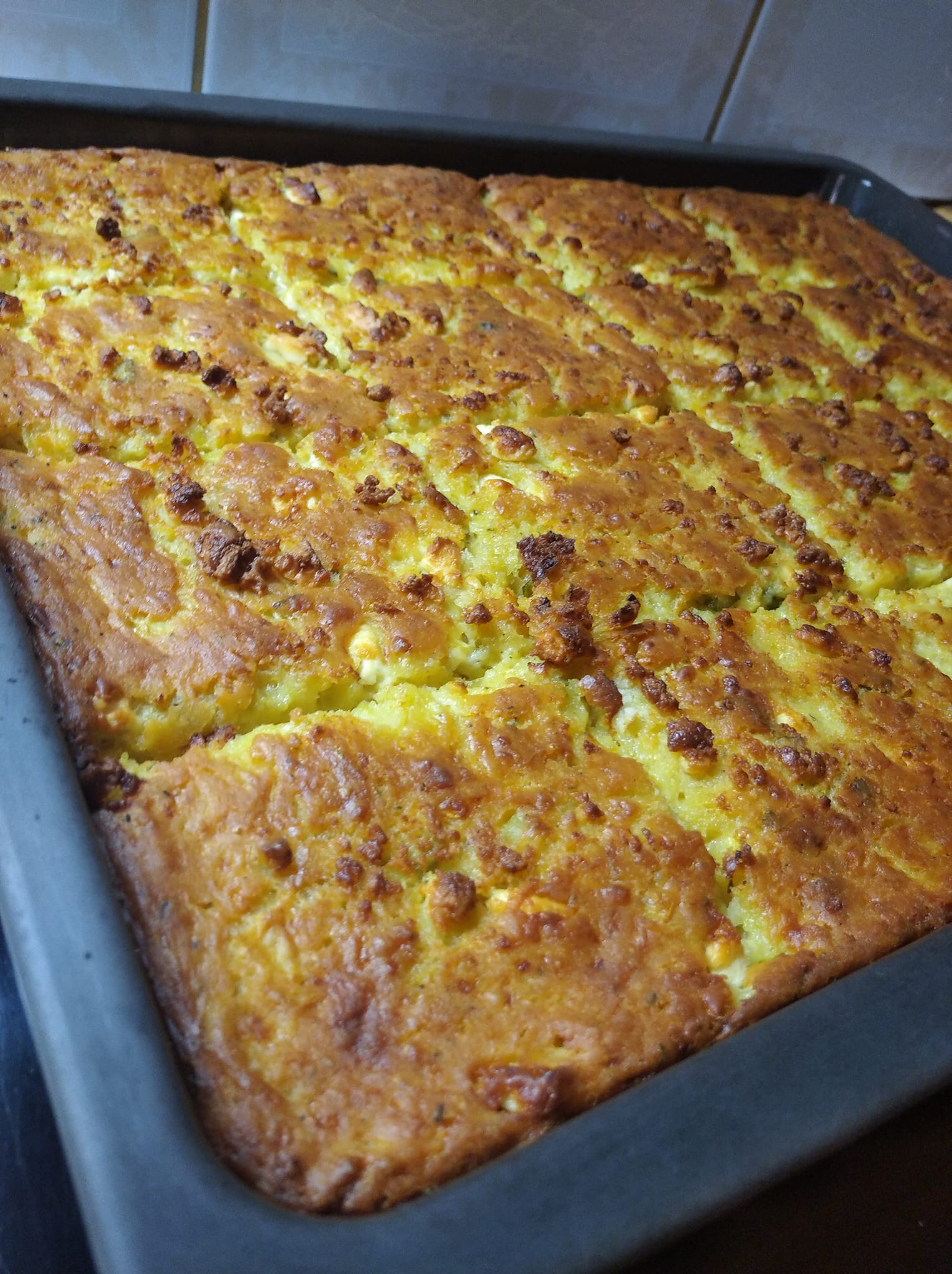 kourkoutopita Ένα ταψι χρυσαφένιας κουρκουτόπιτας (μπατζίνας) με ορατά κομμάτια τριμμένου κολοκυθιού και φέτας.