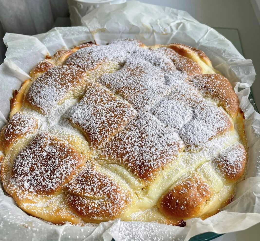 Εμα ταψί από ζουμερή πίτα με μήλο και τυρί, με ορατή τη γέμιση και το πλέγμα από τυρί στην επιφάνεια.