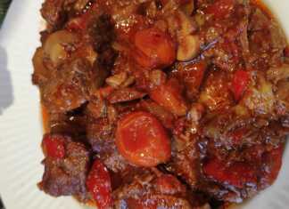 Ζουμερά κομμάτια μοσχαρίσιου κρέατος μέσα σε κόκκινη σάλτσα με πιπεριές και ντοματίνια σερβιρισμένα δίπλα σε λευκό ρύζι πιλάφι