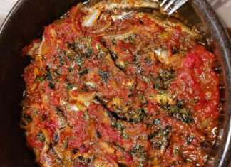 Καλοψημένες Σαρδέλες με ντομάτα και σκόρδο μέσα σε ταψί, καλυμμένες με κόκκινη σάλτσα και πασπαλισμένες με μπόλικο φρέσκο μαϊντανό