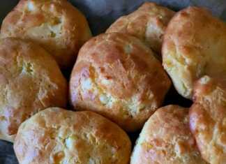 Χρυσαφένια τυροψωμάκια από καλαμποκάλευρο τοποθετημένα σε σειρά πάνω σε λαδόκολλα με λιωμένο βούτυρο στην κορυφή τους