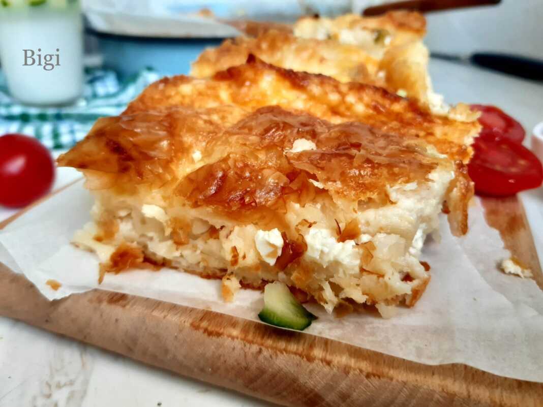 Κομμάτι από την τυρόπιτα, που φαίνεται η ζουμερή γέμιση και οι στρώσεις από το φύλλο κρούστας