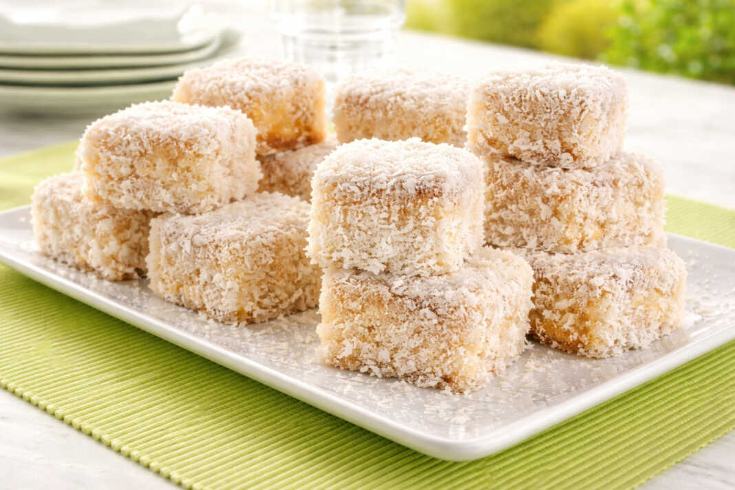 Λευκά Σιροπιαστά κεκάκια πασπαλισμένα με μπόλικο τριμμένο ινδοκάρυδο, κομμένα σε ομοιόμορφα τετράγωνα κομμάτια