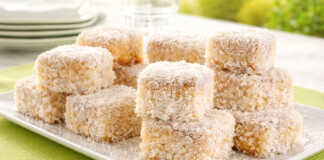 Λευκά Σιροπιαστά κεκάκια πασπαλισμένα με μπόλικο τριμμένο ινδοκάρυδο, κομμένα σε ομοιόμορφα τετράγωνα κομμάτια