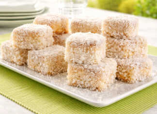 Λευκά Σιροπιαστά κεκάκια πασπαλισμένα με μπόλικο τριμμένο ινδοκάρυδο, κομμένα σε ομοιόμορφα τετράγωνα κομμάτια