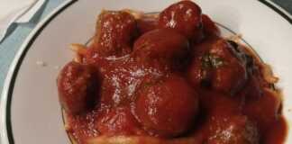 Ένα πιάτο με μακαρόνια και κεφτεδάκια κοκκινιστά, περιχυμένα με κόκκινη σάλτσα.