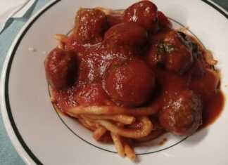 Ένα πιάτο με μακαρόνια και κεφτεδάκια κοκκινιστά, περιχυμένα με κόκκινη σάλτσα.