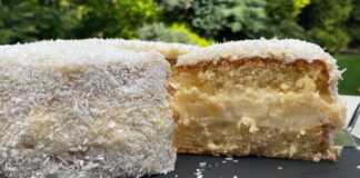 Το τελειωμένο **Κέικ Καρύδας με Κρέμα** πασπαλισμένο με τριμμένη καρύδα.