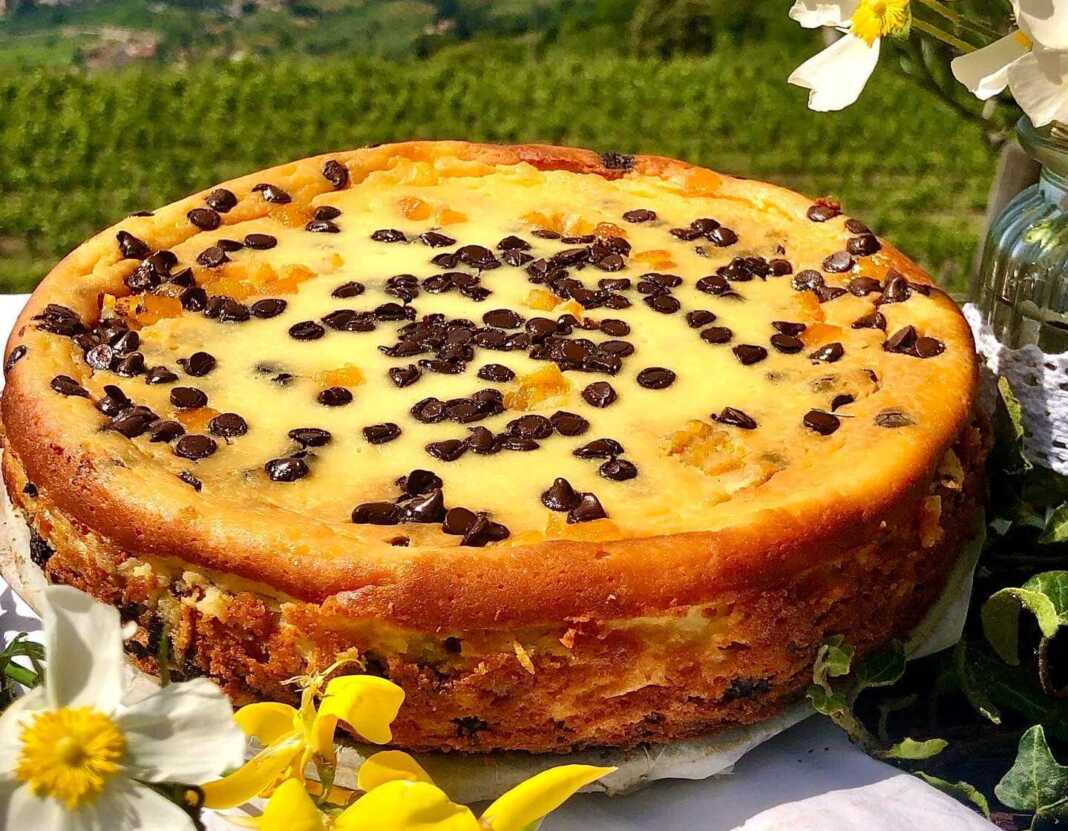 Λαχταριστό Cheesecake πορτοκαλιού με σοκολάτα, διακοσμημένο με σοκολατάκια και φλούδες πορτοκαλιού.