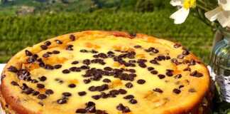 Λαχταριστό Cheesecake πορτοκαλιού με σοκολάτα, διακοσμημένο με σοκολατάκια και φλούδες πορτοκαλιού.