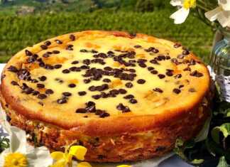 Λαχταριστό Cheesecake πορτοκαλιού με σοκολάτα, διακοσμημένο με σοκολατάκια και φλούδες πορτοκαλιού.