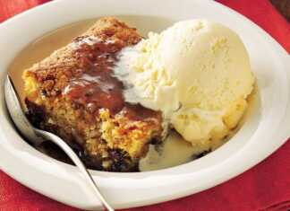 Ένα κομμάτι καφέ κέικ σε ένα άσπρο πιάτο, με σκούρα σάλτσα καραμέλας να το σιροπιάζει