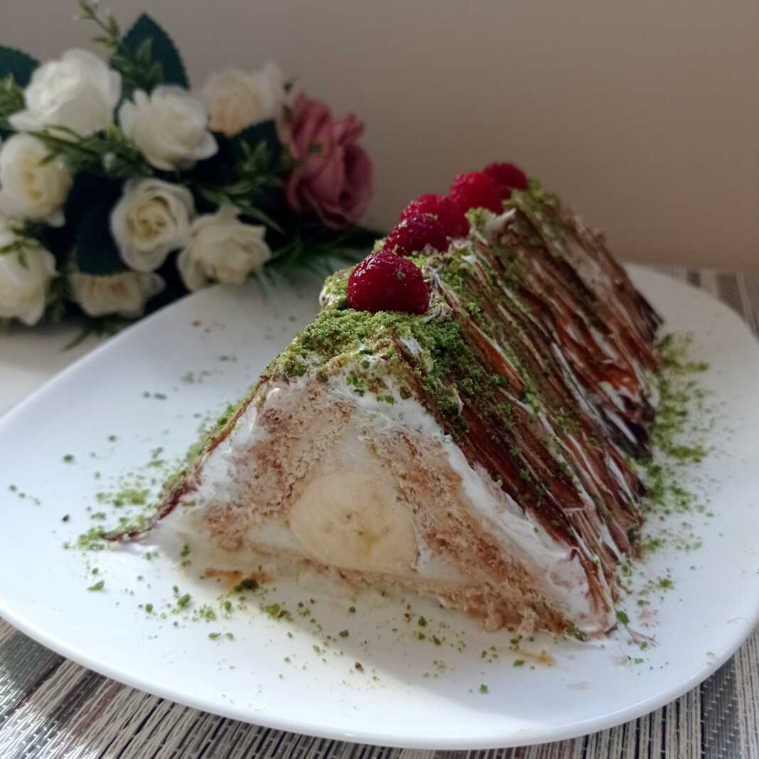 Μπισκότο κέικ σε σχήμα πυραμίδας διακοσμημένο με σοκολάτα, φιστίκι Αιγίνης και σμέουρα.