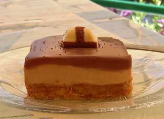 Cheesecake με Kinder σοκολάτα Τεμάχιο cheesecake με Kinder σοκολάτα, με στρώσεις μπισκότου, κρέμας και γκανάς, διακοσμημένο με Kinder Bueno.